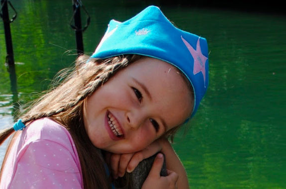 Mädchen in Kleid aus rosa Biojersey mit Krone